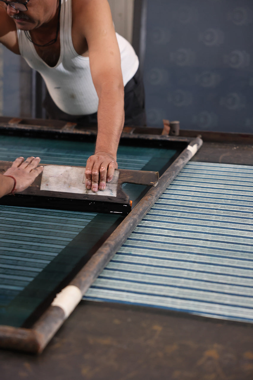 Person working with a screen printing press to create Kyra Mini Spearmint