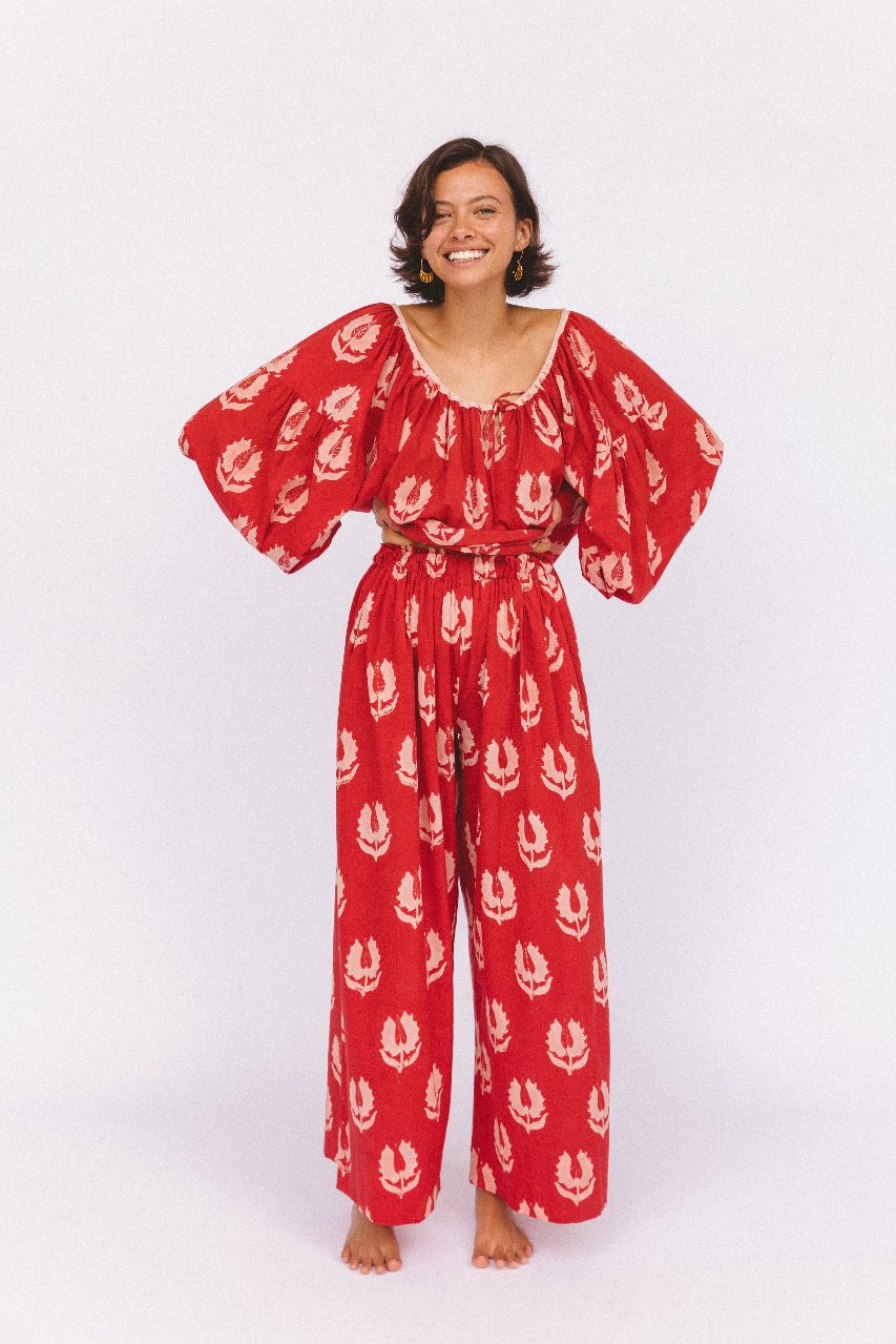 Ria Pants Ruby Red — studio upper body close-up, model wearing ruby red hand block print cotton blouse with botanical leaf motif, scoop neckline and balloon sleeves, gold earrings, artisan Jaipur India | Daughters of India