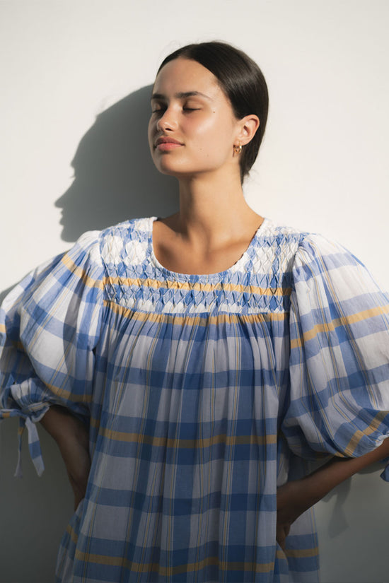 Freya Dress Periwinkle Blue Plaid — upper body close-up showing hand-smocked neckline panel with gold thread detail, handloom woven periwinkle blue plaid with yellow accent, artisan craftsmanship | Daughters of India